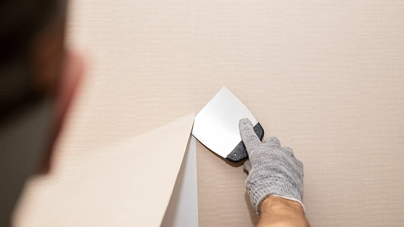 Old wallpaper scraped off a wall before skim-coating it smooth